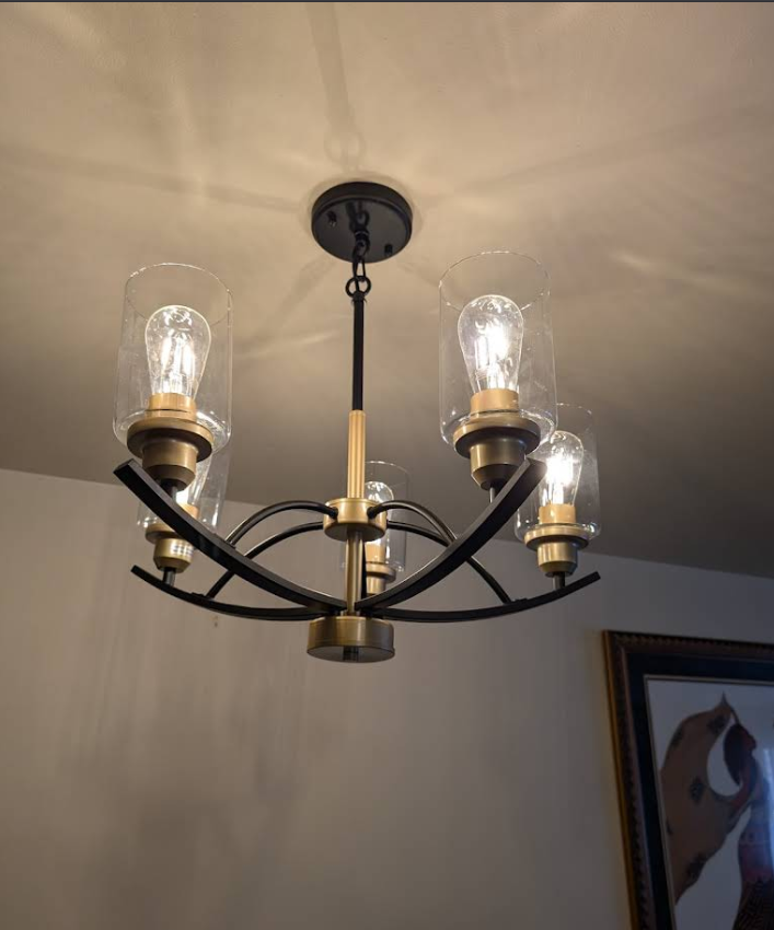 Black and brass five-arm chandelier installed on ceiling